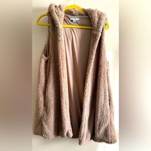 Stylish vest with hoodie, lining, and pockets.